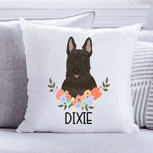 A square-shaped cushion with a personalised design featuring an illustration of a Scottish Terrier dog within a floral pattern, with the name 'Dixie' below it.
