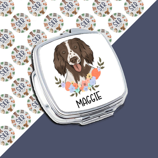 A personalised compact mirror with an illustration of a Springer Spaniel dog and floral design on the front, with the name 'Maggie' printed on the side.