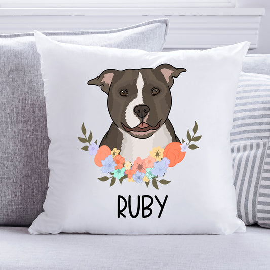 A square-shaped white cushion with a printed image of a dog surrounded by a floral pattern, with the name 'Staffy' at the bottom.