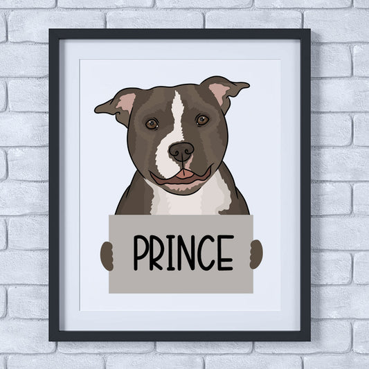 A framed poster of a Staffordshire Bull Terrier dog with the name 'Prince' written at the bottom, held in a simple wooden frame.